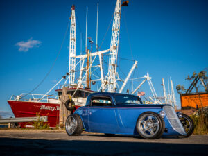 Chris Leso’s Factory Five 33 Hot Rod parked in front of a boat